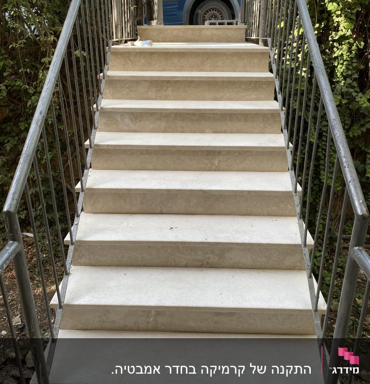 מדרגות שיש עם מעקה מתכת, בקבוק פלסטיק על המדרגה העליונה